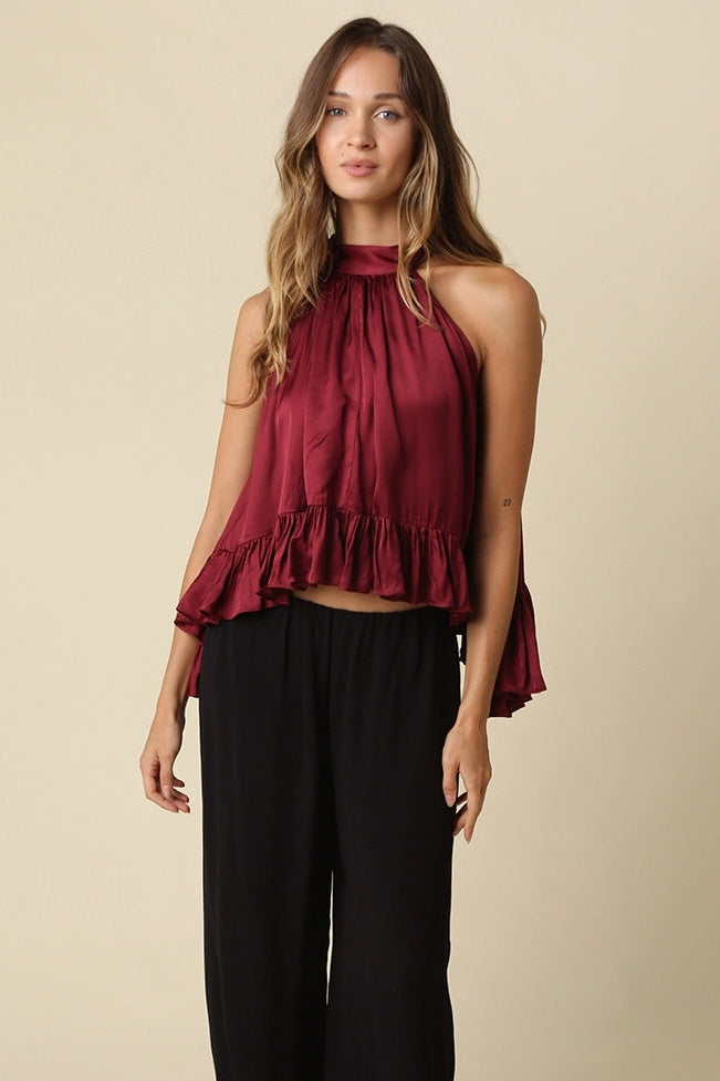 sleeveless satin high-neck top in deep burgundy with a ruffled hem