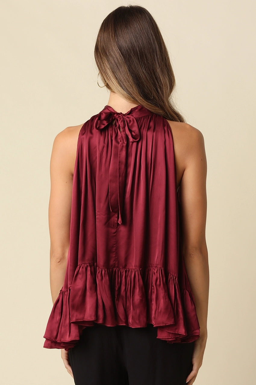 sleeveless satin high-neck top in deep burgundy with a ruffled hem