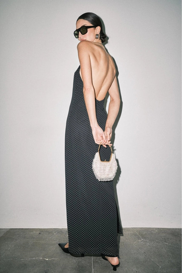 long black halter maxi dress with a small white polka dot pattern and open back