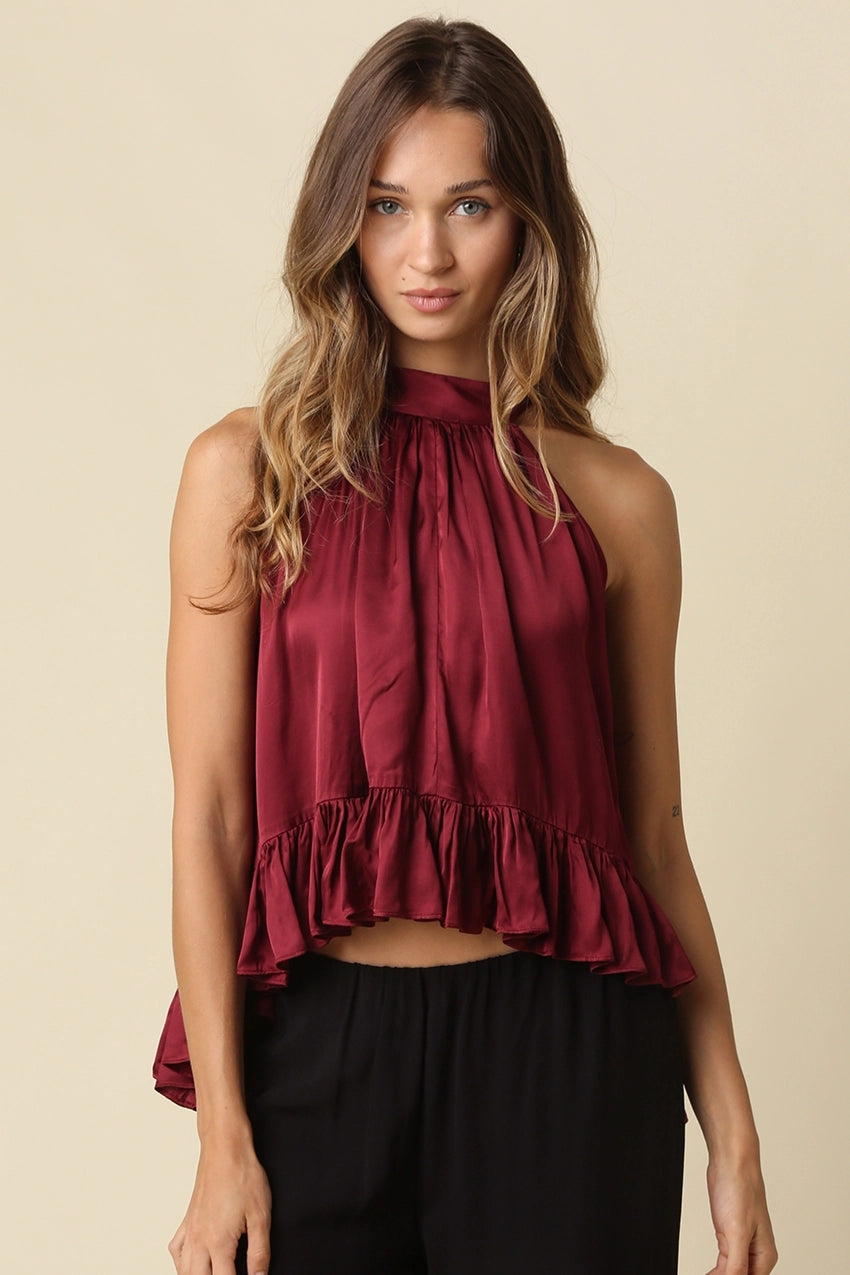 sleeveless satin high-neck top in deep burgundy with a ruffled hem